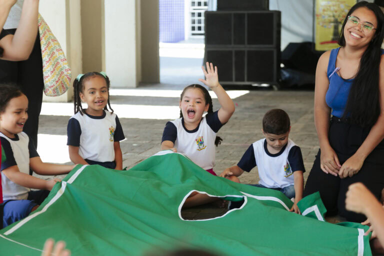Tenda literária com crianças participando de atividades culturais no festival à tarde.