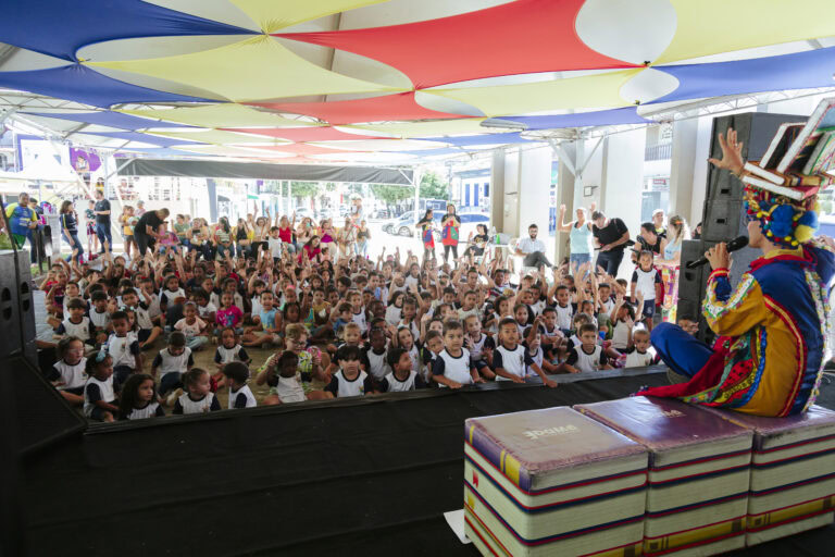 Espectáculo infantil com palhaço e leitura na Tenda Literária de Coroaci, atraindo crianças e famíli.