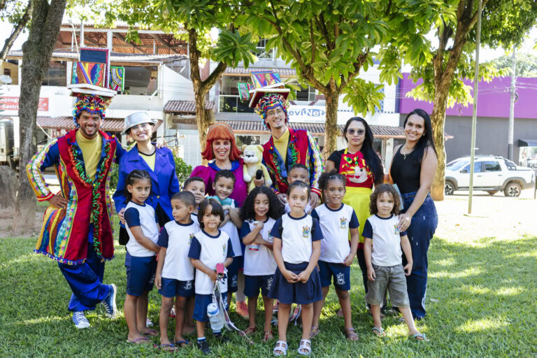 Imagem de crianças e adultos participando do Festival Tenda Literária em Coroaci, com personagens de.