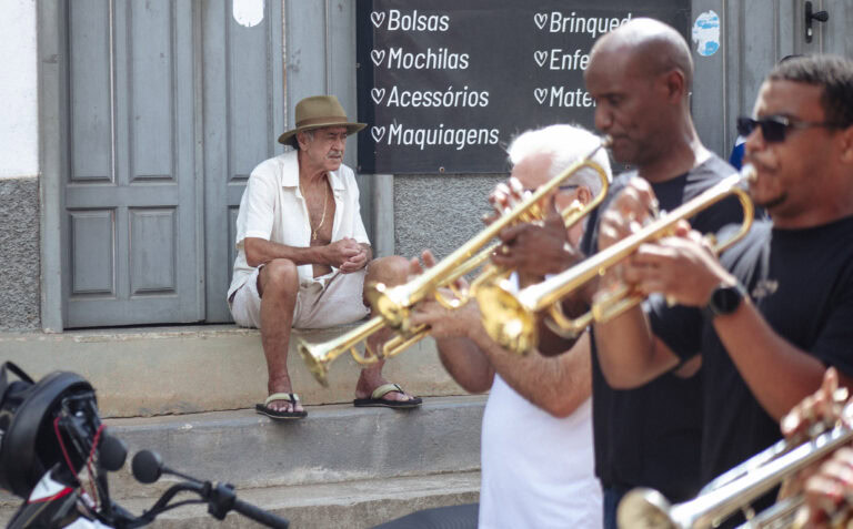 Banda de música tocando na rua durante evento cultural em Antônio Dias.