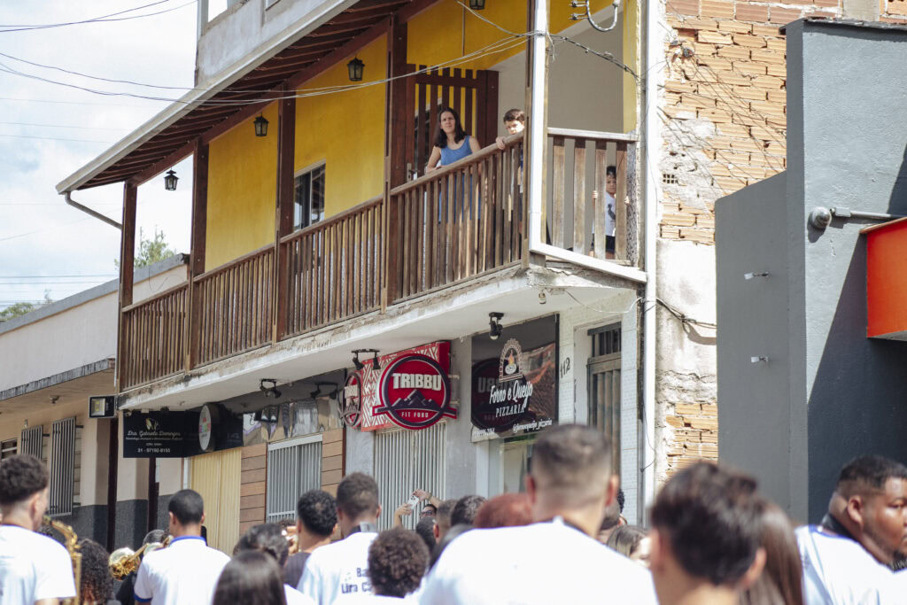 Encontro de bandas de música em Antônio Dias durante evento cultural com público e músicos.