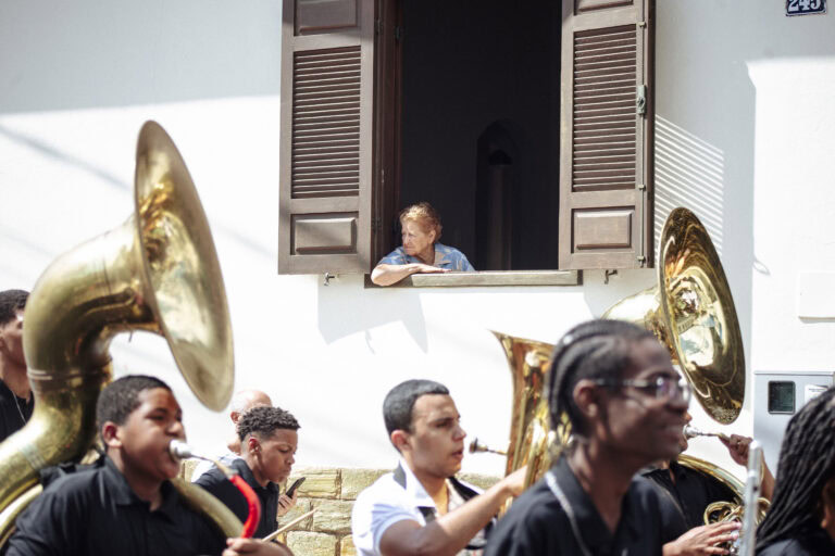 Encontro de bandas de música de Antônio Dias com músicos tocando instrumentos de sopro na rua.