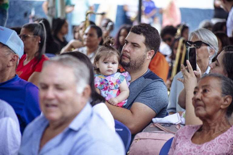 Encontro de Bandas de Música de Antônio Dias com público diversificado.