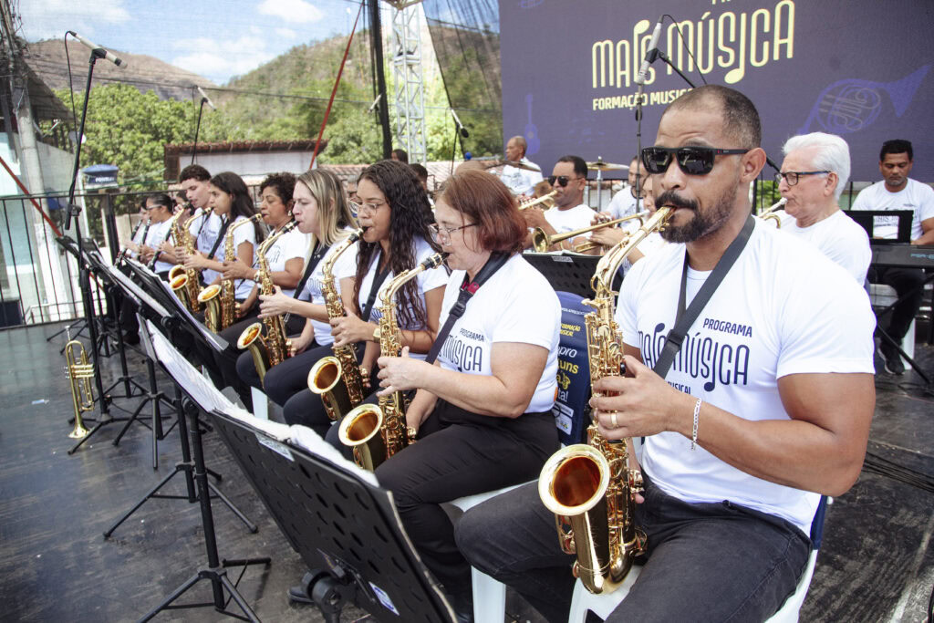 Banda de música tocando ao ar livre durante evento cultural em Antônio Dias.