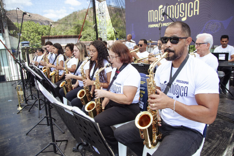Banda de música tocando ao ar livre durante evento cultural em Antônio Dias.