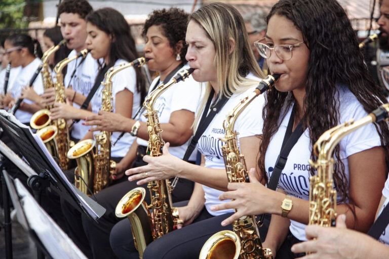 Banda de música tocando em evento cultural de Antônio Dias, destacando talento e união musical.