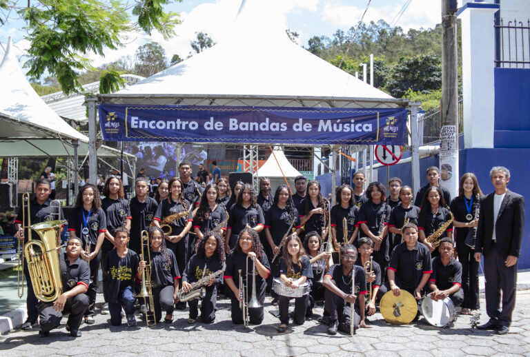 Encontro de Bandas de Música de Antônio Dias com jovens músicos e maestros ao ar livre.