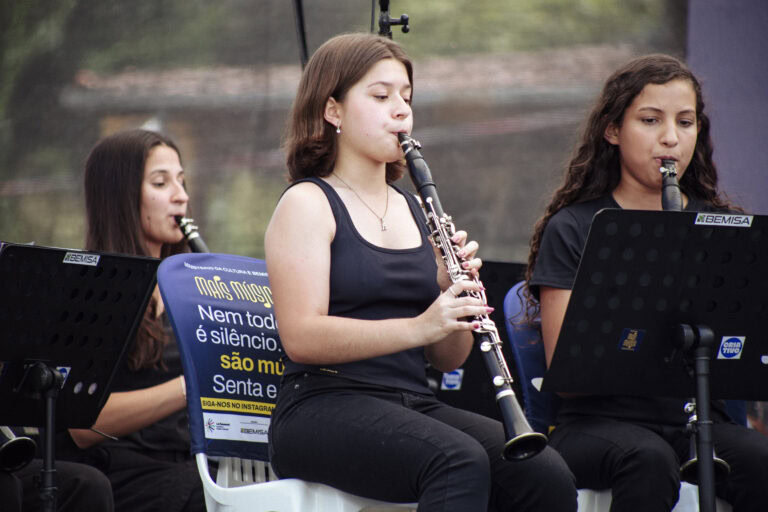 Banda de música tocando durante o encontro em Antônio Dias, evento cultural com apresentações musica.