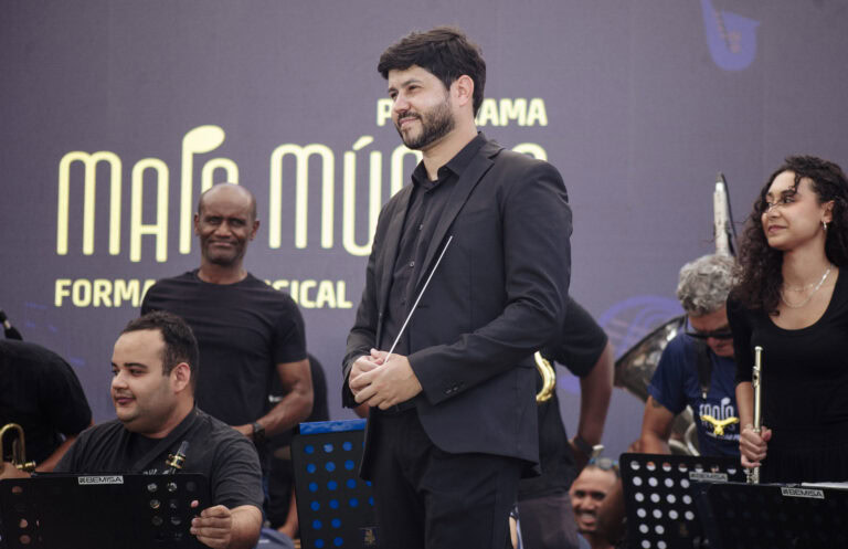 Imagem de um maestro conduzindo banda musical no evento em Antônio Dias.