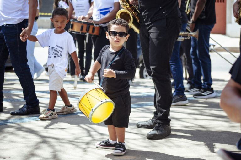 Participantes de bandas de música durante o encontro em Coronel Fabriciano, com crianças tocando ins.