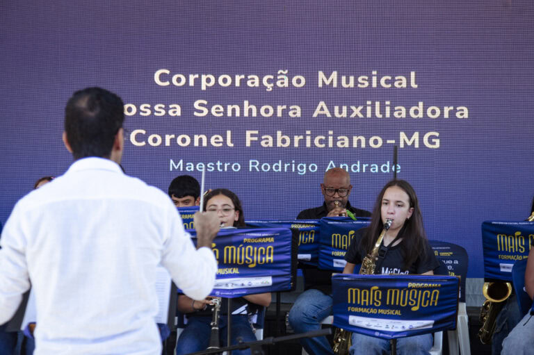 Encontro de bandas de música em Coronel Fabriciano com maestros e músicos em apresentação ao vivo.