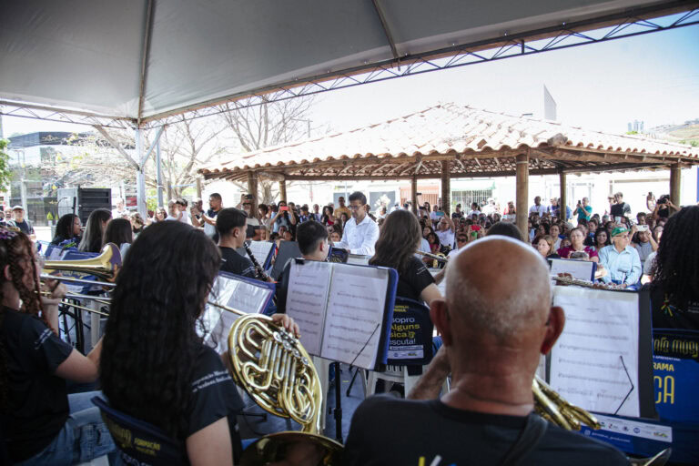 Encontro de bandas de música com músicos tocando instrumentos em evento ao ar livre.