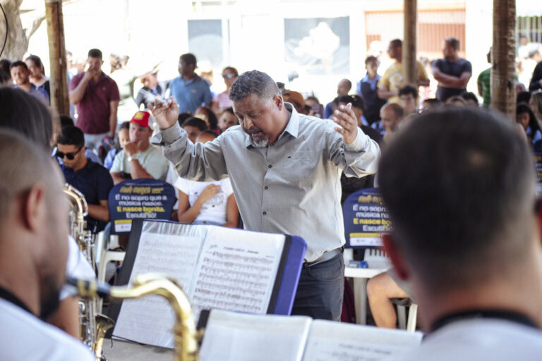 Diretor de banda conduz ensaio durante encontro musical em Coronel Fabriciano.