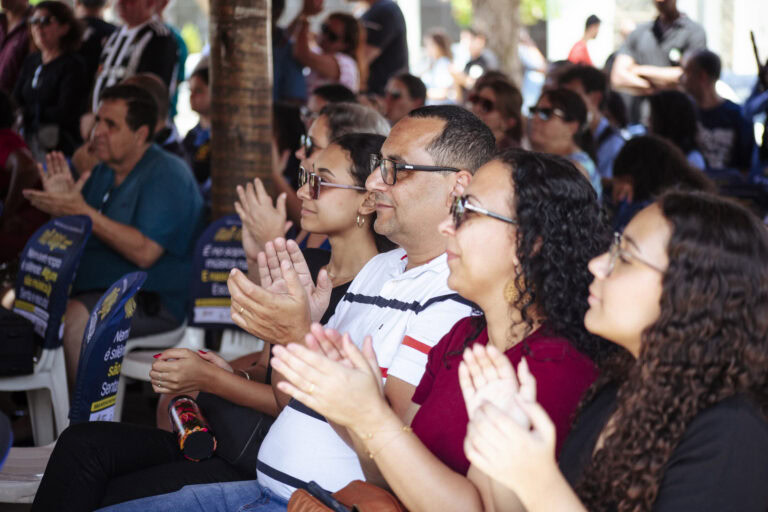 Imagem de pessoas assistindo ao Encontro de Bandas de Música de Coronel Fabriciano, demonstrando ent.