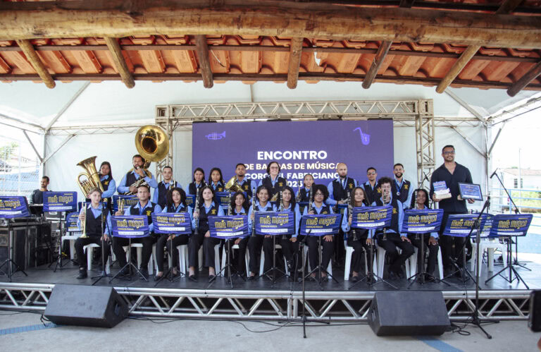 Encontro de bandas de música em Coronel Fabriciano com jovens músicos em apresentação ao ar livre.