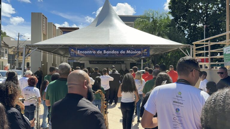 Encontro de Bandas de Música de Coroaci com público assistindo ao show ao ar livre.