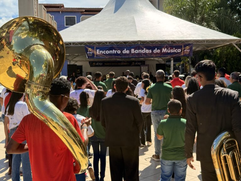 Evento musical com bandas de Coroaci, público assistindo ao vivo na praça ao ar livre.