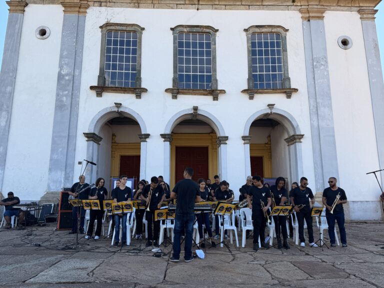 Encontro de bandas de música de Catas Altas com jovens músicos tocando ao ar livre.