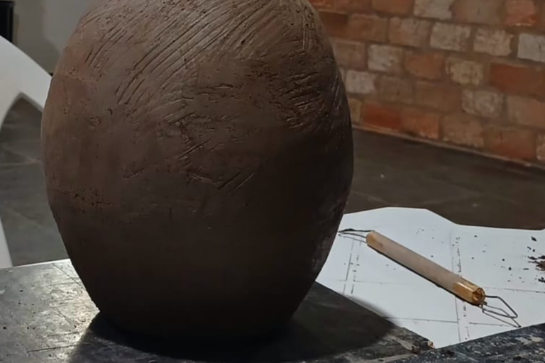 Vaso de cerâmica artesanal em processo de criação, destaque para textura e acabamento rústico.