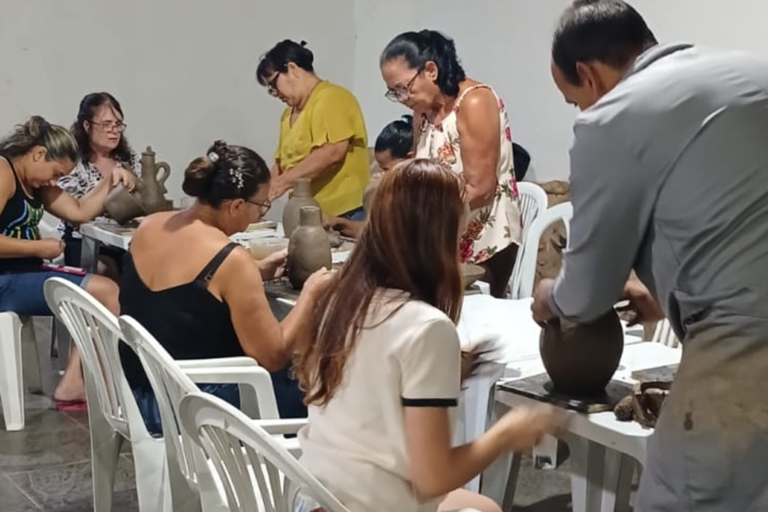 Aula de artesanato em cerâmica com participantes criando peças artesanais.
