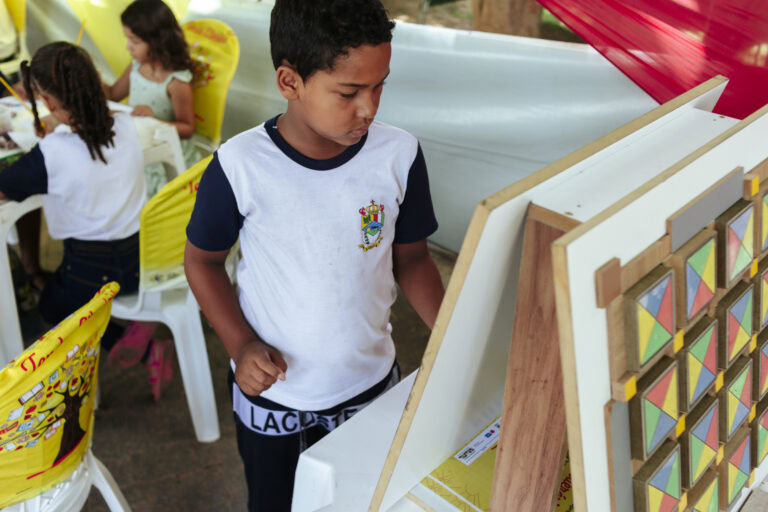 Criança apreciando atividades culturais na Tenda Literária Coroaci durante o festival.