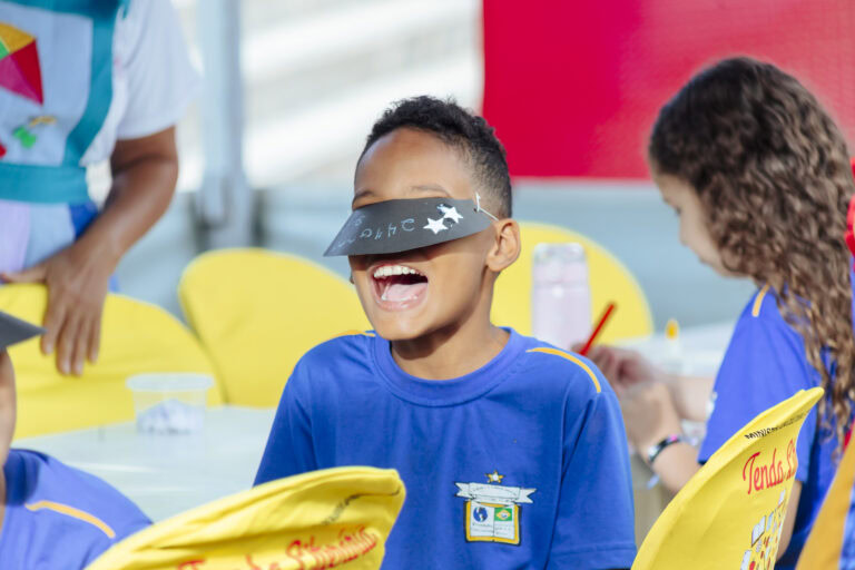 Imagem de crianças participando do Festival Tenda Literária Rio Vermelho, com destaque para uma cria.
