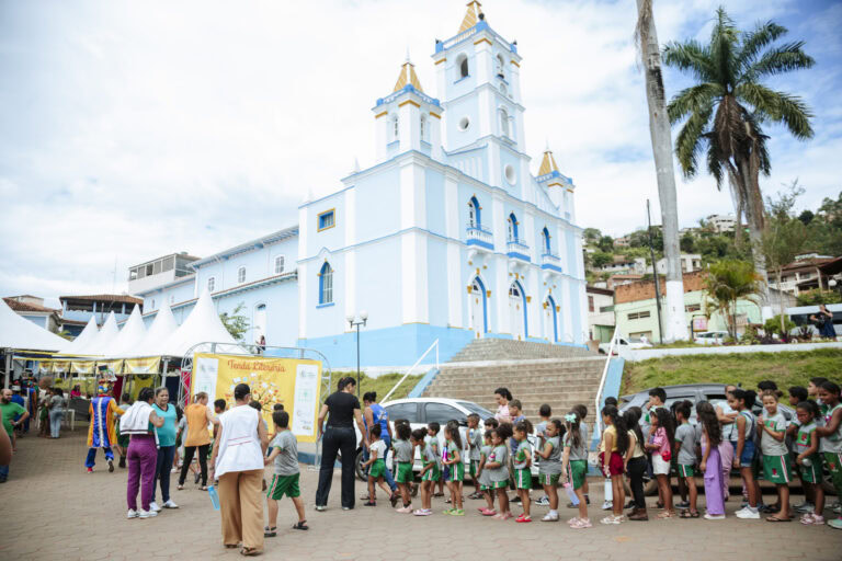 Tenda Literária Rio Vermelho durante evento cultural com crianças e adultos na frente de uma igreja.