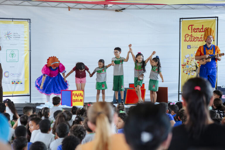 Imagem de crianças no palco durante o Festival Tenda Literária Rio Vermelho, com público assistindo.