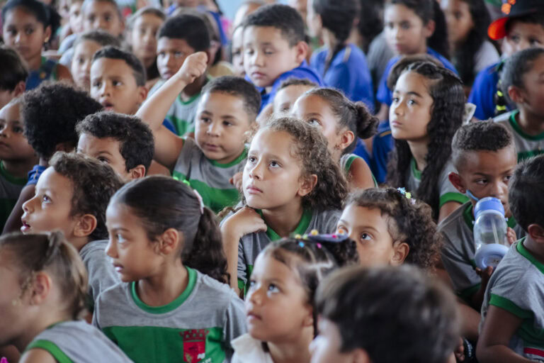 Evento infantil com crianças participando de atividades culturais ao ar livre.