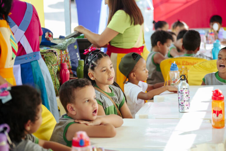 Tenda literária com crianças participando de atividades culturais no Festival Rio Vermelho.