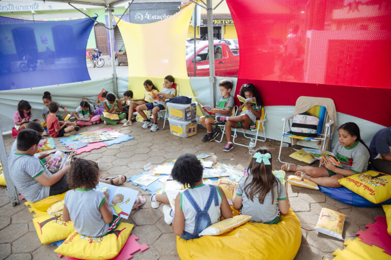 Atividades de leitura na Tenda Literária Rio Vermelho com crianças participando de contação de histó.