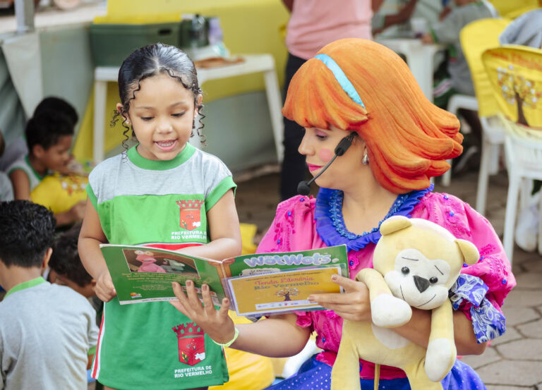 Personagem de palhaça lendo livro para criança na Tenda Literária Rio Vermelho, evento cultural infa.