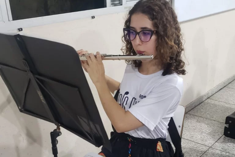 Técnica tocando flauta durante aula de música na escola Criativo Produções.