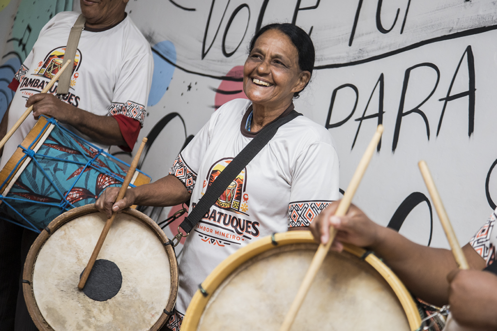 Imagem de mulheres tocando tambor em aula de tambatuques, celebrando cultura brasileira.