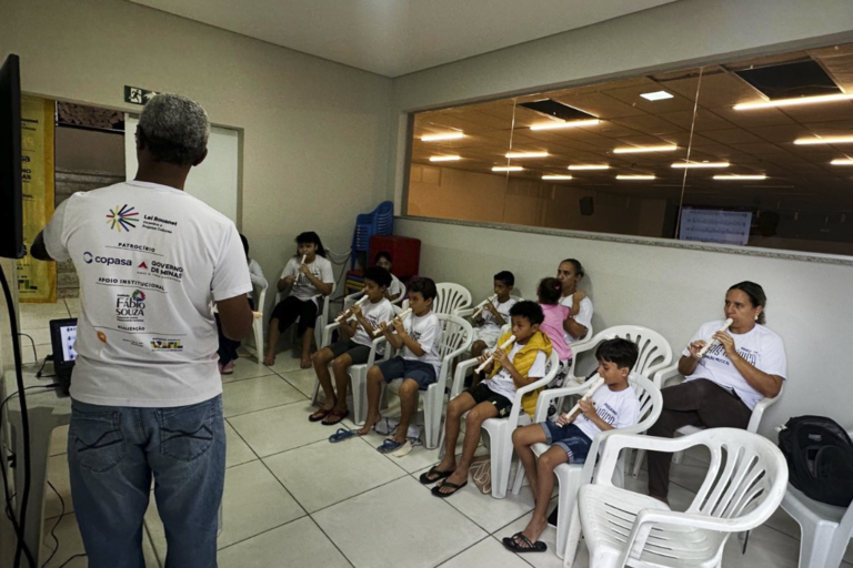 Aula de flauta doce com crianças em sala de aula, orientadas por instrutor na Criativo Produções.