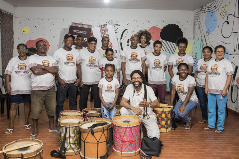 Aula de tambor com alunos participando de atividade musical especial.