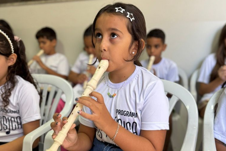 Aula de flauta doce com crianças aprendendo música em sala de aula.
