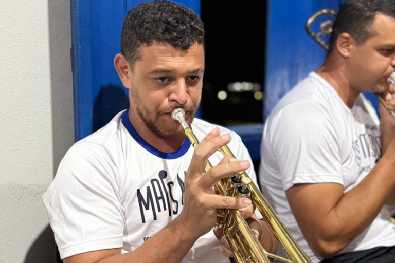 Técnico de som ajustando equipamento de áudio durante apresentação musical.