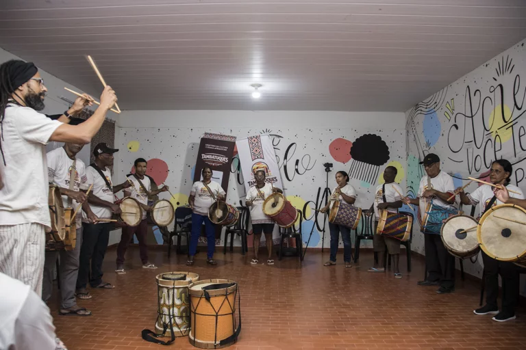 Aula de tambatuques com alunos participando de atividade musical especial.