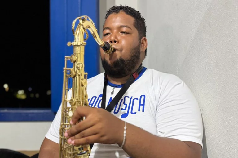 Músico tocando saxofone durante apresentação ao vivo, destacando talento musical e paixão pela músic.