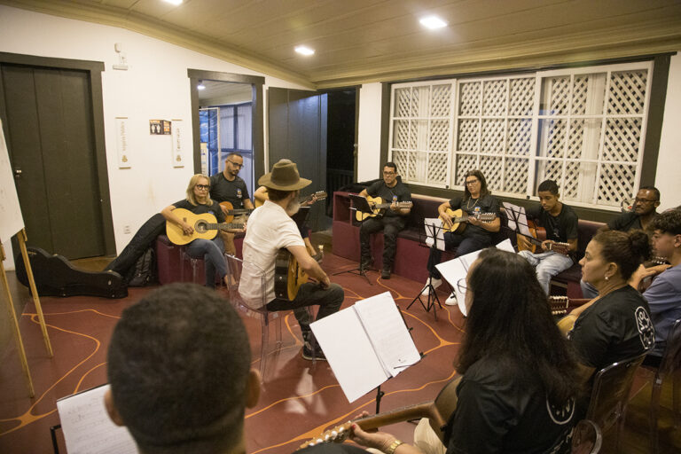Atividade musical com violas e músicos em ensaio para evento cultural.