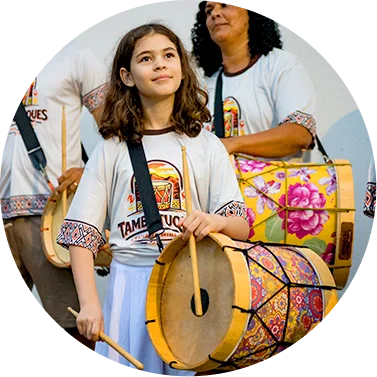 Tambores tradicionais em apresentação cultural com crianças e adultos, destacando a musicalidade e a.