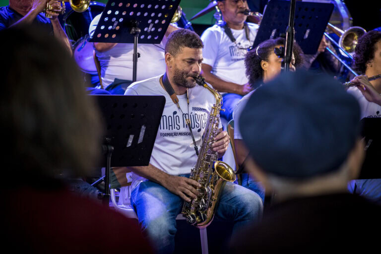 Músico tocando saxofone na orquestra Som de Minas ao vivo.