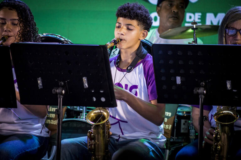 Jovem saxofonista tocando em apresentação ao vivo.