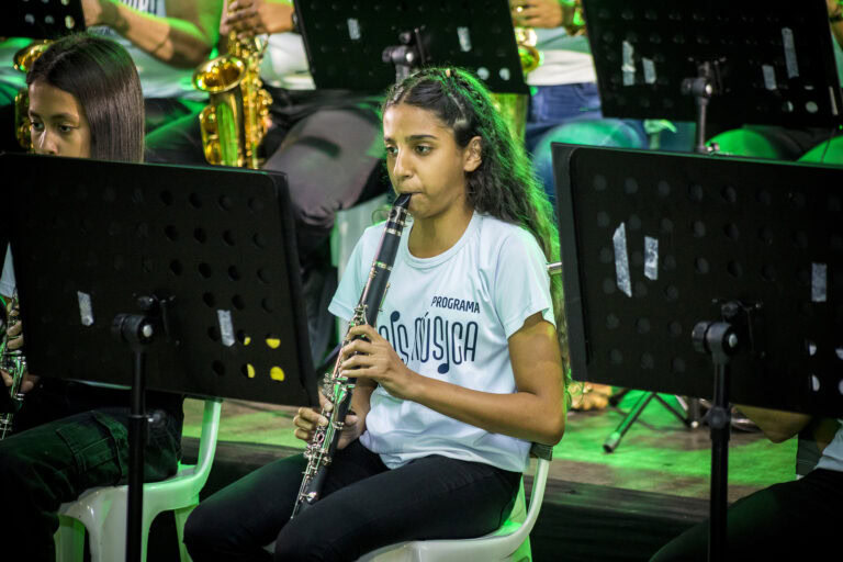 Jovem musicista tocando clarinete na orquestra de Minas Gerais.