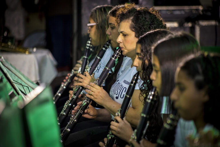 Mulheres tocando clarinetes em uma orquestra ao vivo.