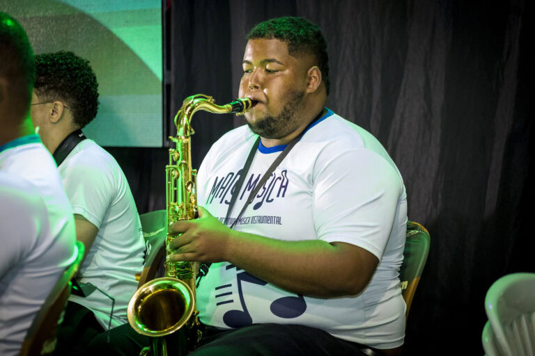 Músico tocando saxofone durante evento musical em Minas Gerais.