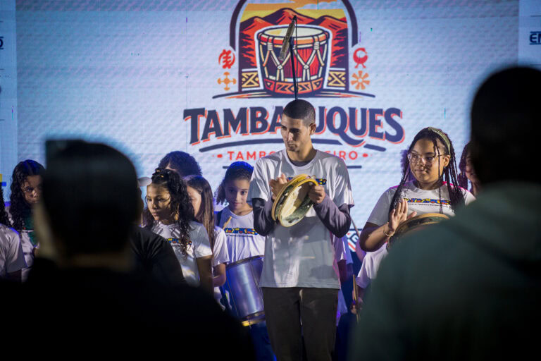 Grupo de crianças tocando instrumentos tradicionais no Festival Tambatuques.