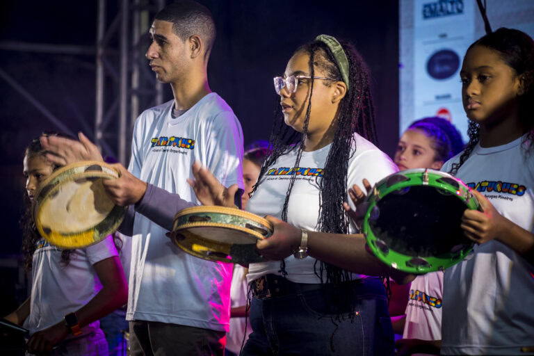 Grupo de jovens tocando tamborins durante o Festival Tambatuques.